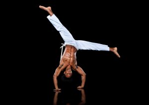 Man practising capoeira, in handstand position